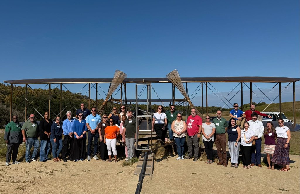 AAERO Network participants pose in front of plane sculpture at the Wright Brother's Memorial in Dare County, NC