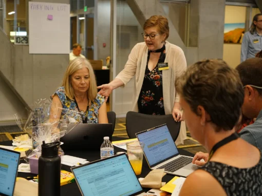 Former App State Empowering Teacher Learning (ETL) Navigator Sherry Paddie, center, instructs an ETL participant on how to access her Digital Promise microcredential library at the ETL Summer Convening held at App State in July 2025.